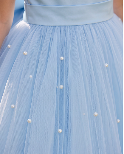 Close-up of a light blue tulle skirt with a wide matching waistband and scattered pearl embellishments.