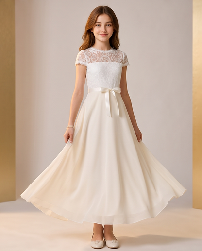 A young girl models a cream-colored formal dress with a lace bodice, short cap sleeves, and a matching fabric bow at the waist, set against a neutral studio backdrop.
