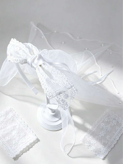 White lace veil with a bow on a light gray background