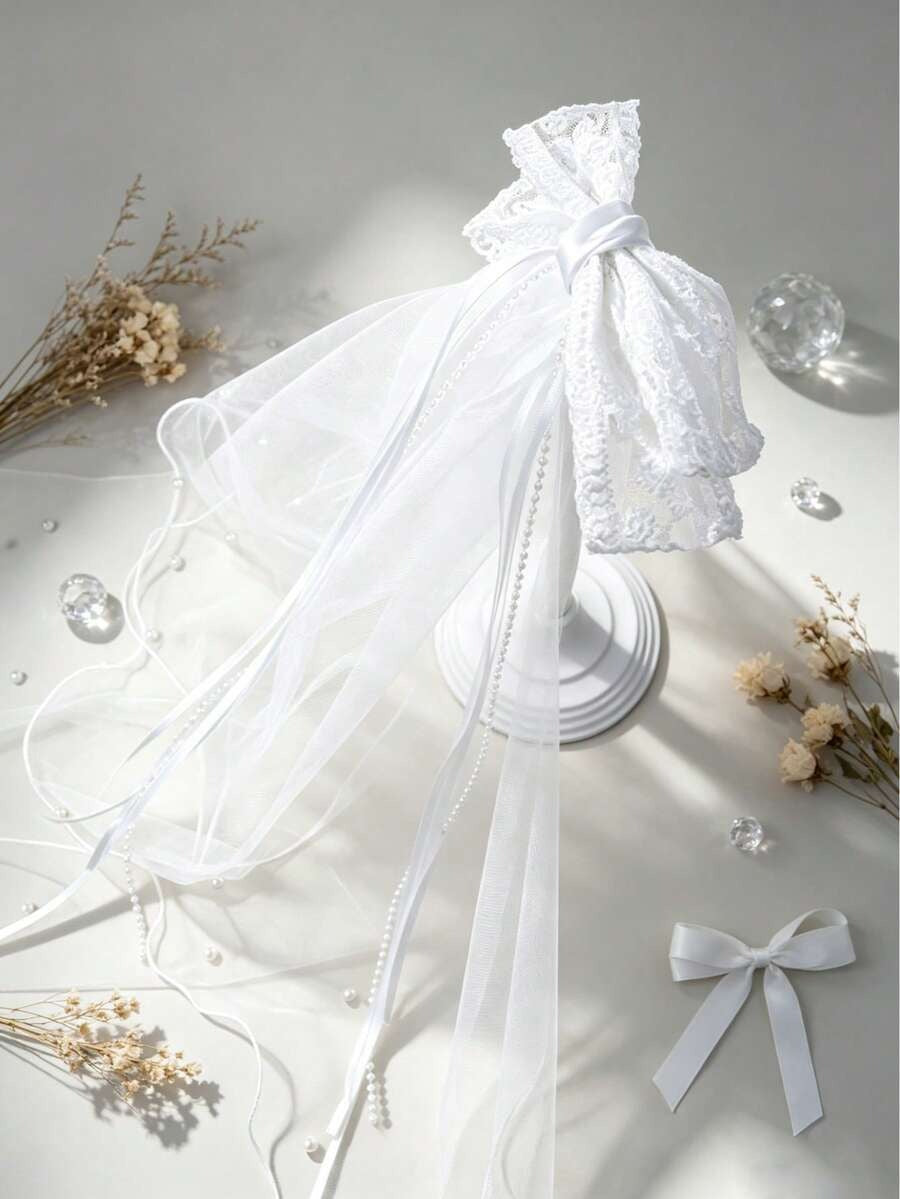 White lace veil headband with ribbons on a light gray background