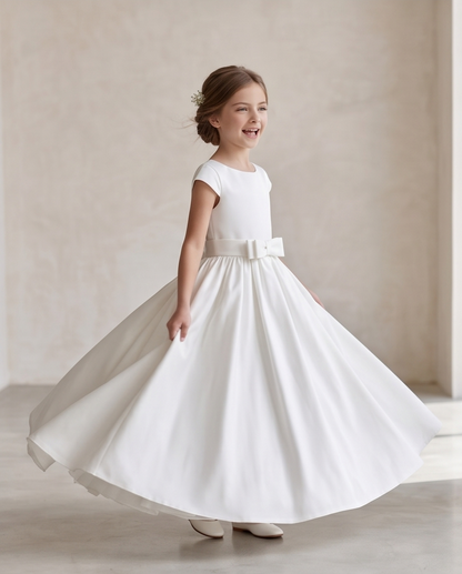 Young girl wearing a white dress with a belt in a neutral setting