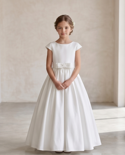 Young girl wearing a white dress with a belt in a neutral setting